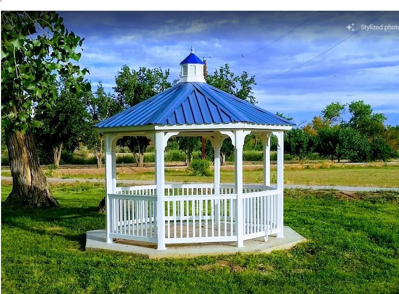 White gazebo with a blue roof on a grassy New Mexico lawn