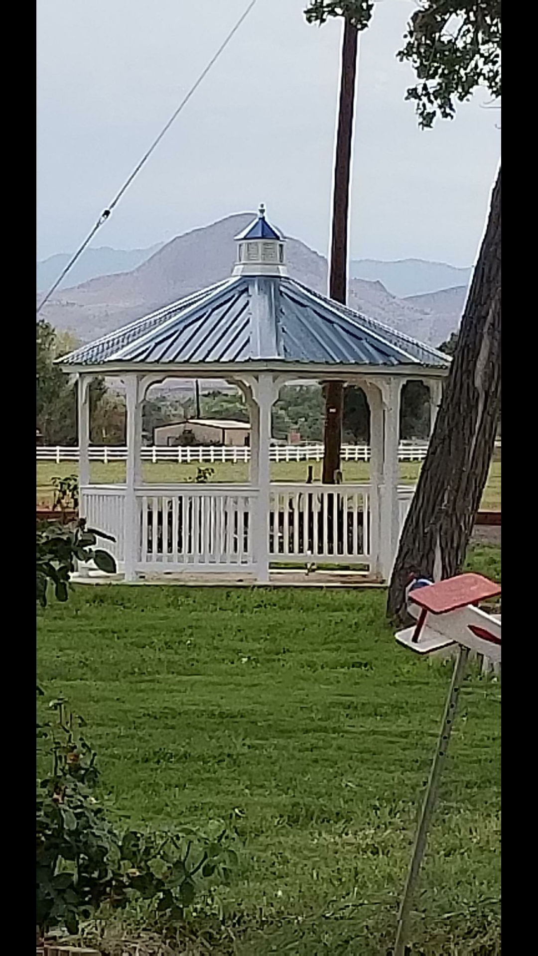 White gazebo with a blue roof against the New Mexico mountains